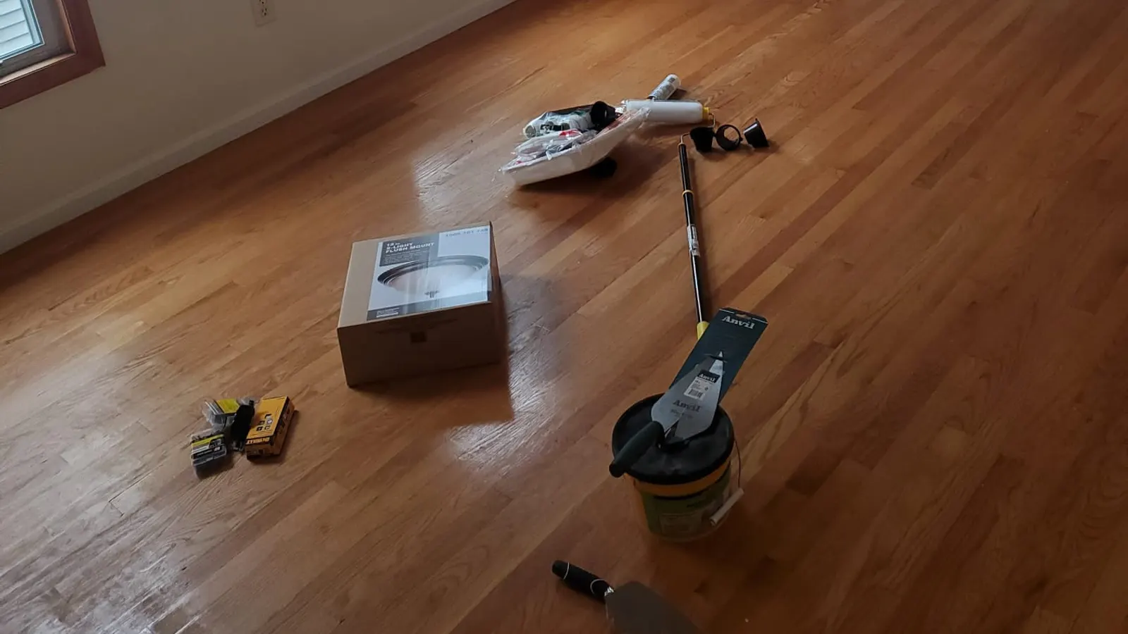 Hardwood floor refinishing in Lynn, MA with a sander and tools in the room